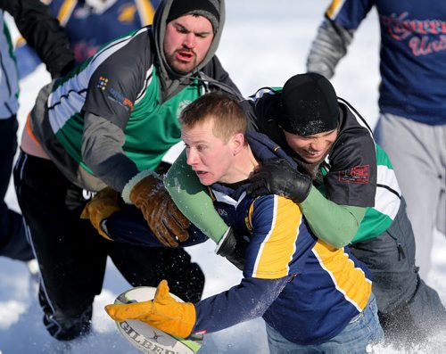 Kris Pritchard and John Rhoda of the Winnipeg Wanderers tackle Andrew Sheldon of the Winnipeg Saracens during the Winnipeg Wasps Snow 7's Annual Rugby Tournament on the intersection of the Red and Assiniboine Rivers, Saturday, February 15, 2014. (TREVOR HAGAN/WINNIPEG FREE PRESS)