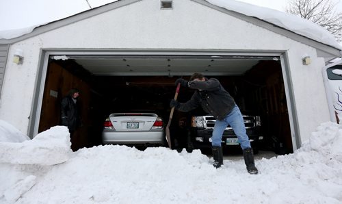 Lisa Harrison and Gord Perry removing a large buildup of snow and ice chunks that the city's snow plows behind a Pritchard Avenue home, Sunday, February 16, 2014. (TREVOR HAGAN/WINNIPEG FREE PRESS)