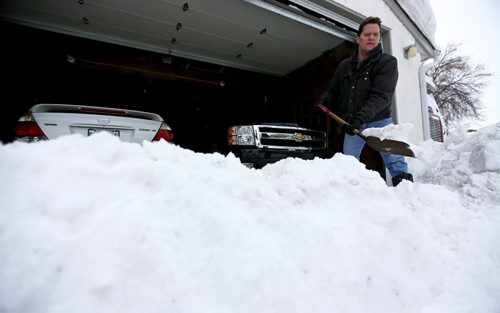 Gord Perry removing a large buildup of snow and ice chunks that the city's snow plows behind a Pritchard Avenue home, Sunday, February 16, 2014. (TREVOR HAGAN/WINNIPEG FREE PRESS)
