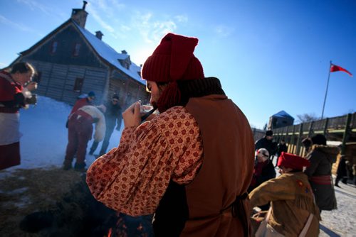 Barney Morin lights his tobacco pipe before telling a story at a camp du feu (fire camp) at Festival Du Voyageur on Louis Riel Day.  140217 - Monday, {month name} 17, 2014 - (Melissa Tait / Winnipeg Free Press)