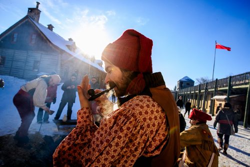 Barney Morin lights his tobacco pipe before telling a story at a camp du feu (fire camp) at Festival Du Voyageur on Louis Riel Day.  140217 - Monday, {month name} 17, 2014 - (Melissa Tait / Winnipeg Free Press)