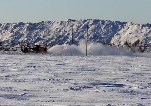 Stdup - Daunting  task as a high speed plough blasts snow on Rossmore Ave.  with the McPhillips St.  city snow dump that looks more like a mountain range in the north  perimeter area   of Wpg . FEB. 18 2014 / KEN GIGLIOTTI / WINNIPEG FREE PRESS
