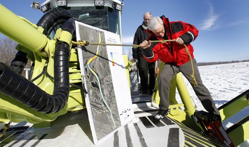 After the news conference, Premier Greg Selinger climbs off of one of the three Amphibex ice breaking machines out on the Red River north of Selkirk by Netley Creek Tuesday morning part of the 2014 ice jam mitigation program.  Bruce Owen story. Wayne Glowacki / Winnipeg Free Press Feb. 18   2014