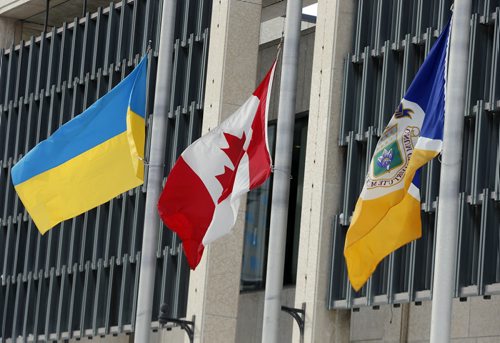 STDUP - LtoR , The  The City of Wpg Flag , Canadian Flag and Ukrainian Flag all stand at half mast  in front of Winnipeg City Hall .FEB. 19 2014 / KEN GIGLIOTTI / WINNIPEG FREE PRESS