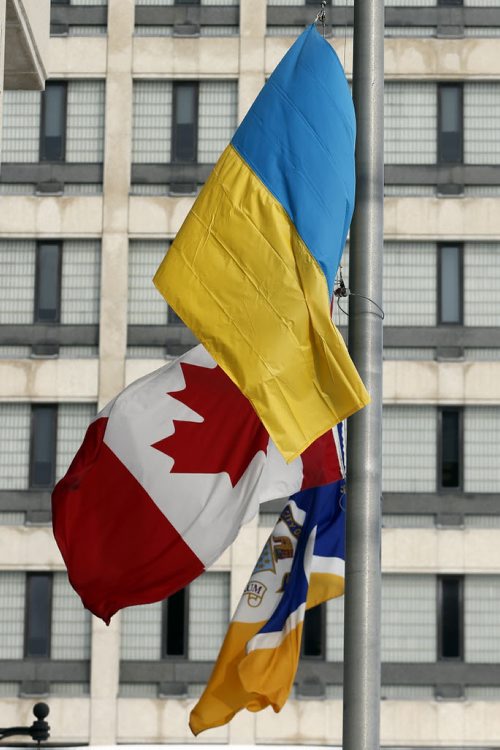 STDUP - The  The City of Wpg Flag , Canadian Flag and Ukrainian Flag all stand at half mast  in front of Winnipeg City Hall .FEB. 19 2014 / KEN GIGLIOTTI / WINNIPEG FREE PRESS