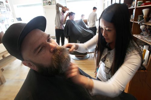 Hunter & Gunn barber shop at 567 Broadway- Kim Nguyen  trims customer Sean Reicos beard-    See  Geoff Kirybyson story- Feb 19, 2014   (JOE BRYKSA / WINNIPEG FREE PRESS)