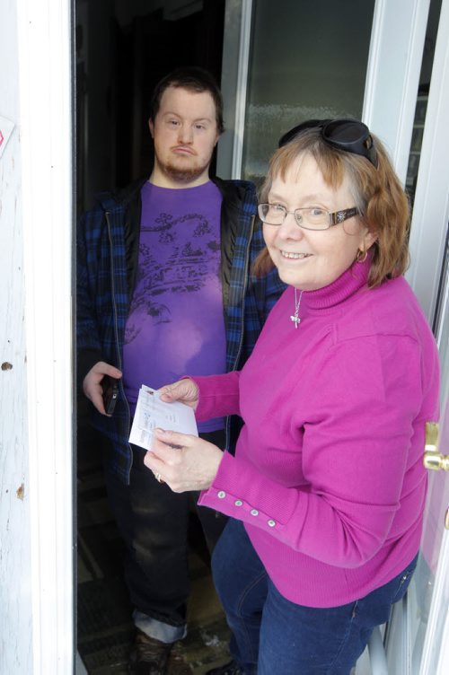 Val Surbey and her son Timothy getting mail from the box.   her neighbourhood is one of the first in Canada that will lost home delivery this fall. Shes with Community Living Manitoba and concerned about what will happen to neighbours with mobility issues when Canada Post service is cut.. BORIS MINKEVICH / WINNIPEG FREE PRESS  Feb. 20/14
