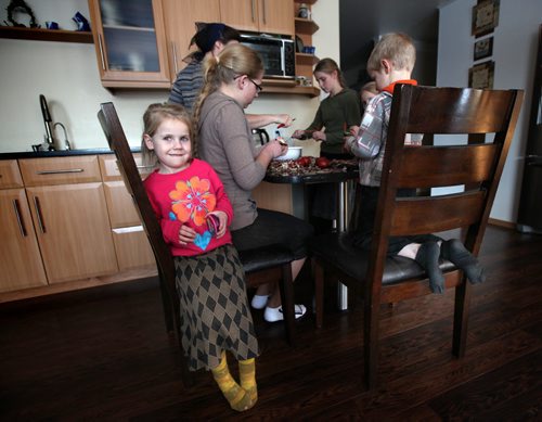 Nelly DIK (5) plays coy for the camera while a few of her 16 siblings peel potatoes for their supper. See Bill Redecopp story AND Video re: 13 orphaned kids adopted by their Uncle and Aunt. February 20, 2014 - (Phil Hossack / Winnipeg Free Press)
