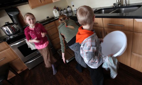 Left to RIght, Lisa (8) Anika (13), and Nathan ((7) make fun out of kitchen chores Thursday.  See Bill Redecopp story AND Video re: 13 orphaned kids adopted by their Uncle and Aunt. February 20, 2014 - (Phil Hossack / Winnipeg Free Press)
