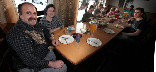 Jacob and Lin Dik sit with the family for their supper. See Bill Redecopp story AND Video re: 13 orphaned kids adopted by their Uncle and Aunt. February 20, 2014 - (Phil Hossack / Winnipeg Free Press)