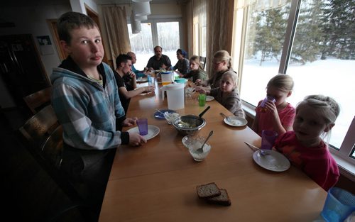 Johannes (14) gets up to start clearing dishes from the supper table. See Bill Redecopp story AND Video re: 13 orphaned kids adopted by their Uncle and Aunt. February 20, 2014 - (Phil Hossack / Winnipeg Free Press)