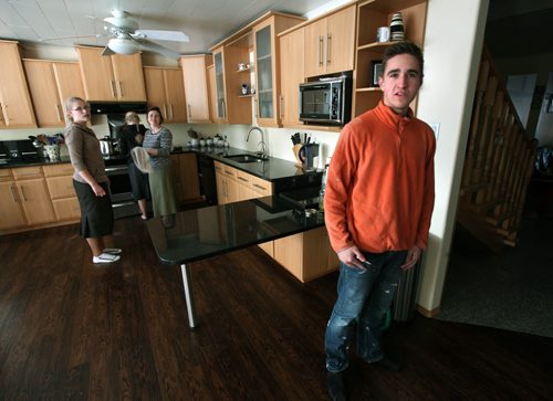 17 yr old Sam arrives home from work while Mom and two sisters work in the kitchen. See Bill Redecopp story AND Video re: 13 orphaned kids adopted by their Uncle and Aunt. February 20, 2014 - (Phil Hossack / Winnipeg Free Press)
