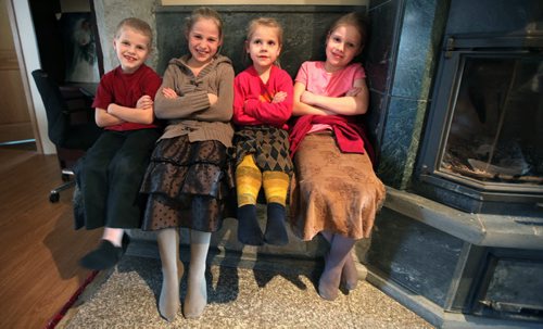 Left to Right, Nathan (7), Helen (10), Nelly (5) and Lisa (8) sit beside a wood heater in the family home near Kleefeld. See Bill Redecopp story AND Video re: 13 orphaned kids adopted by their Uncle and Aunt. February 20, 2014 - (Phil Hossack / Winnipeg Free Press)