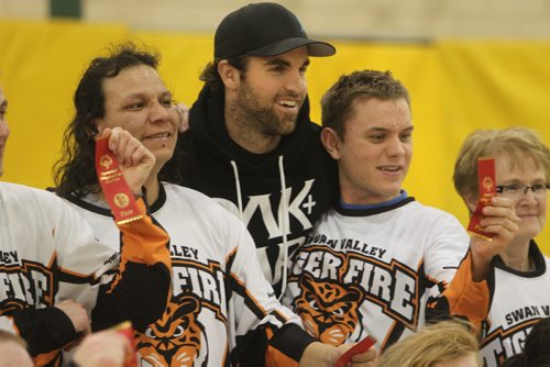 Winnipeg Jets captain Andrew Ladd poses with the 1st place Winter Games floor hockey team winners- the Swan Valley Tiger Fire at the end of their games Saturday.  The 34th Annual Kinsmen Winnipeg Winter Games a part of Special Olympics Manitoba took place at St. John's Ravenscourt and featured activities such as snowshoeing, figure skating and floor hockey. Standup photo Feb 22,, 2014 Ruth Bonneville / Winnipeg Free Press