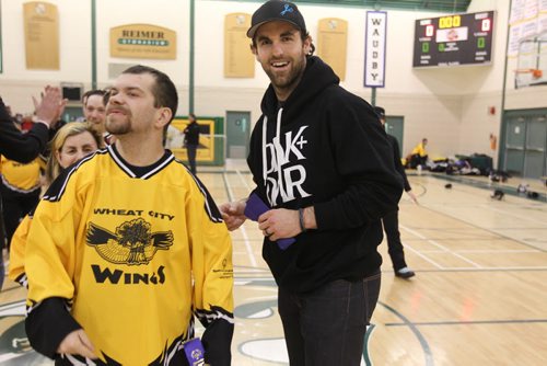 Winnipeg Jets captain Andrew Ladd hands out ribbons to the  2nd place Winter Games floor hockey team winners- the Wheat City Wings from Brandon at the end of their games Saturday.  The 34th Annual Kinsmen Winnipeg Winter Games a part of Special Olympics Manitoba took place at St. John's Ravenscourt and featured activities such as snowshoeing, figure skating and floor hockey. Standup photo Feb 22,, 2014 Ruth Bonneville / Winnipeg Free Press