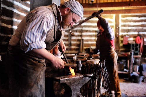 Despite the biting wind hundreds took in the entertainment on the last day of the Festival du Voyageur Sunday. Blacksmith Matt Jenkins forges a hinge post. 140223 - February 23, 2014 MIKE DEAL / WINNIPEG FREE PRESS