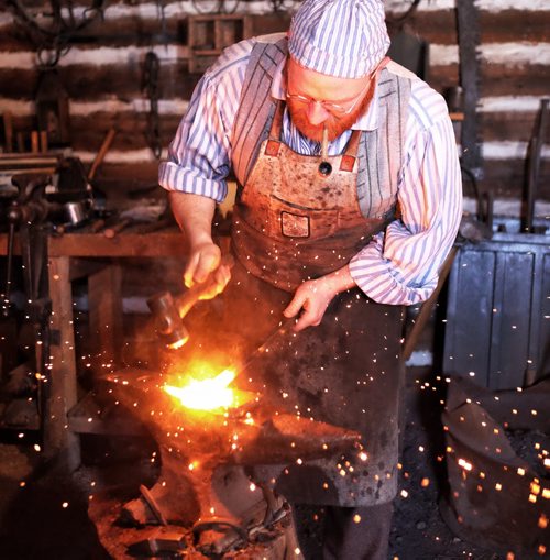 Despite the biting wind hundreds took in the entertainment on the last day of the Festival du Voyageur Sunday. Blacksmith Matt Jenkins forges a hinge post. 140223 - February 23, 2014 MIKE DEAL / WINNIPEG FREE PRESS