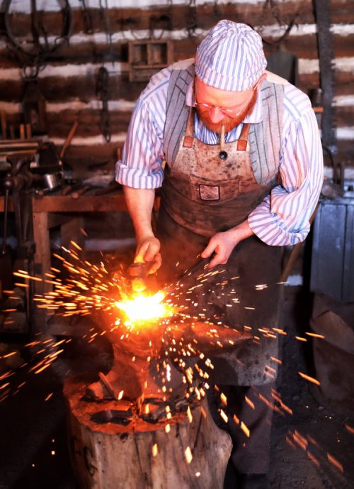 Despite the biting wind hundreds took in the entertainment on the last day of the Festival du Voyageur Sunday. Blacksmith Matt Jenkins forges a hinge post. 140223 - February 23, 2014 MIKE DEAL / WINNIPEG FREE PRESS