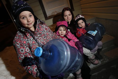 February 24, 2014 - 140224  -  Kaylee Mack and her three young daughters (L to R) Maykenzie (8), Gracelyn (2), and Keanna (5) head out to get water at their grandparents home Monday, February 24, 2014. The Macks have been without water for 8 days after city water lines frozen. City officials cant tell them when the lines will be thawed.  John Woods / Winnipeg Free Press