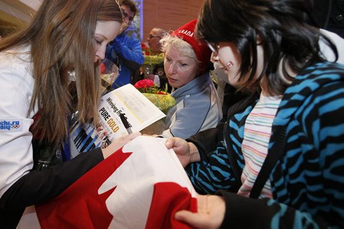 February 24, 2014 - 140224  -  Olympic curling gold medalist Kaitlyn Lawes signs autographs as she and Jennifer Jones (skip), Jill Officer (second), Dawn McEwen (lead), Kirsten Wall (alternate) and their coach Janet Arnott return to hundreds of family and supporters at the Winnipeg Airport Monday, February 24, 2014.  John Woods / Winnipeg Free Press