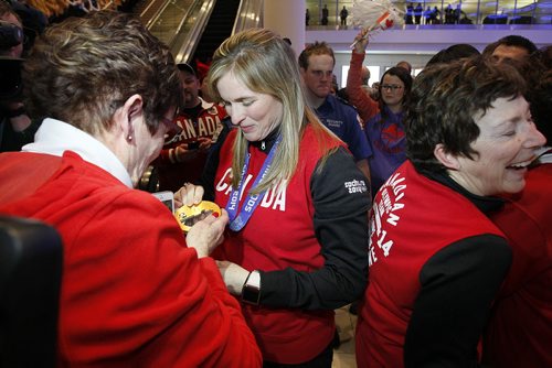 February 24, 2014 - 140224  -  Olympic curling gold medalist Jennifer Jones shows her mother Carol her medal as she and Kaitlyn Lawes (third), Jill Officer (second), Dawn McEwen (lead), Kirsten Wall (alternate) and their coach Janet Arnott return to hundreds of family and supporters at the Winnipeg Airport Monday, February 24, 2014.  John Woods / Winnipeg Free Press