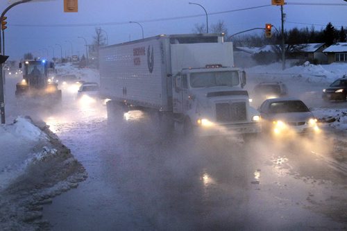 Traffic moves slowly through the water from a large water main break on south bound lanes of Route 90 at Selkirk Ave. on a -25C Tuesday morning.  Wayne Glowacki / Winnipeg Free Press Feb. 25   2014