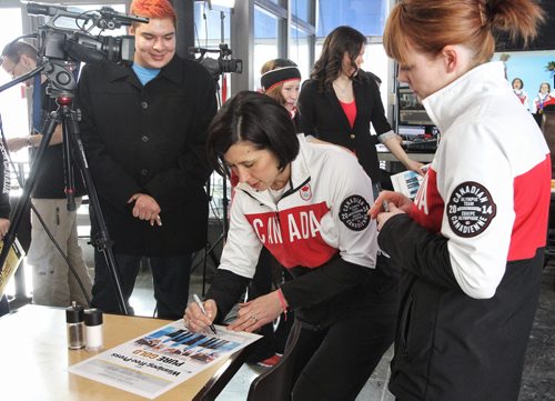 Fan Steven Stevenson (left) gets autographs from Olympians Jill Officer (centre) and Dawn McEwen  (right) as they arrive at the Winnipeg Free Press News Cafe for an interview and Q&A.  140225 February 25, 2014 Mike Deal / Winnipeg Free Press