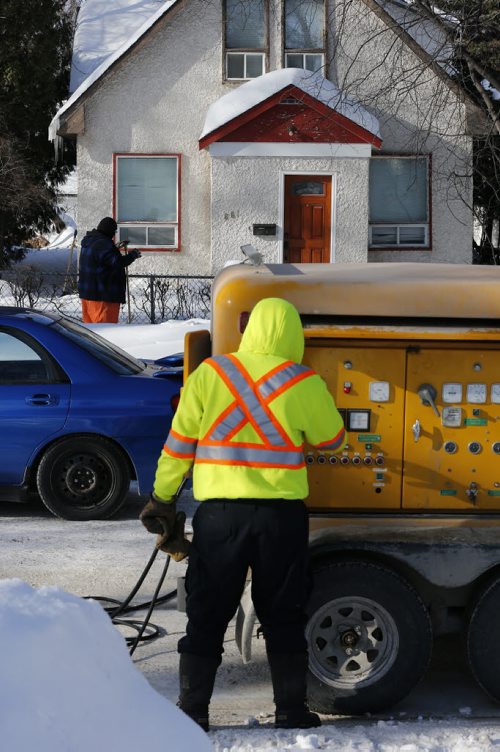 City worker hook up heavy duty battery lines to water lines running under the street on both side to create heat to thaw feozen water lines - LOCAL - A City of Wpg crew was thawing frozen water pipes on Mulvey Ave . The process uses electrical current  from a DBH battery to thaw  frozen pipe  that ran under  the street  to the  home without water . The home owner has been without water for ten days . See video Bart Kives story .  FEB. 26 2014 / KEN GIGLIOTTI / WINNIPEG FREE PRESS
