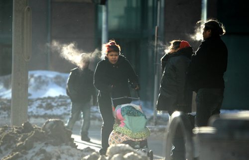 Winnipeger's hurry across Vaughan  Street at Portage Ave in high winds and cold  temperatures Wednesday afternoon. Standup photo Ruth Bonneville / Winnipeg Free Press