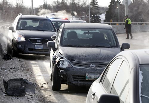 Police direct traffic on the St. James Bridge around a multi-vehicle collision in the north bound lanes Thursday morning. Wayne Glowacki / Winnipeg Free Press Feb. 27   2014