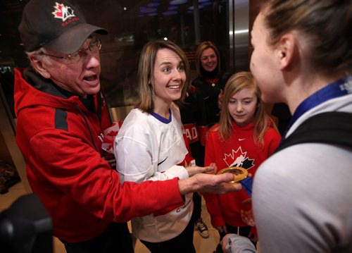 Jocelyne Larocque's, arriving at the James Richardson International Airport, Grandfather and Aunt weigh her gold medal as she arrived in Winnipeg Thursday afternoon. See Mary Agnes Welch story re: Olympic Gold. February 27, 2014 - (Phil Hossack / Winnipeg Free Press)