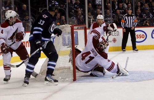 Phoenix Coyotes  goalie MIKE SMITH   (41) trips after Bryan Little's (18) unassisted shot makes it past him making the score 2 - 1 for the Jets in the second period of  NHL action in Winnipeg Thursday night -See story- Feb 27 , 2014 (Ruth Bonneville/WINNIPEG FREE PRESS)