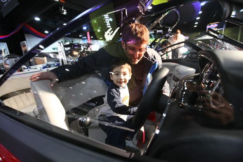A father and son dream as they sit in the drivers seat of a speed boat while attending the Mid-Canada Boat Show at the Convention Centre Saturday. Standup Photo  March 01, 2014 Ruth Bonneville / Winnipeg Free Press