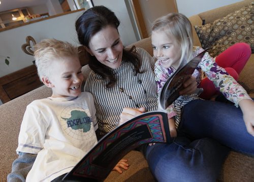 March 2, 2014 - 140302  -  Lorelle Perry reads her book Letters To Our Children with her children Micah (L) and Lillia in their home Sunday, March 2, 2014. Perry is a mom and teacher who started a playgroup called KidBridge for newcomer moms and their children to meet established Cdn moms and preschoolers  now theyre the subject of a book and a documentary being screened on International Womens Day this Saturday. John Woods / Winnipeg Free Press. Carol Sanders story