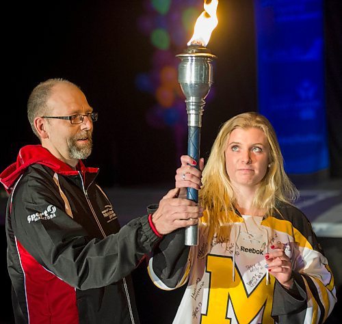 140302 Winnipeg - DAVID LIPNOWSKI / WINNIPEG FREE PRESS - March 02, 2014  Torchbearer Keith Peters passes the torch to Kayleigh Wiens during the opening ceremonies of the 2014 Power Smart Manitoba Games in Morden, MB Sunday night.