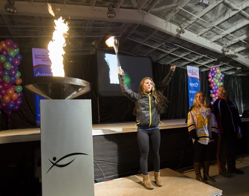 140302 Winnipeg - DAVID LIPNOWSKI / WINNIPEG FREE PRESS - March 02, 2014  Torchbear Amber Wiebe lights the caldron alongside Kayleigh Wiens and Keith Peters during the opening ceremonies of the 2014 Power Smart Manitoba Games in Morden, MB Sunday night.