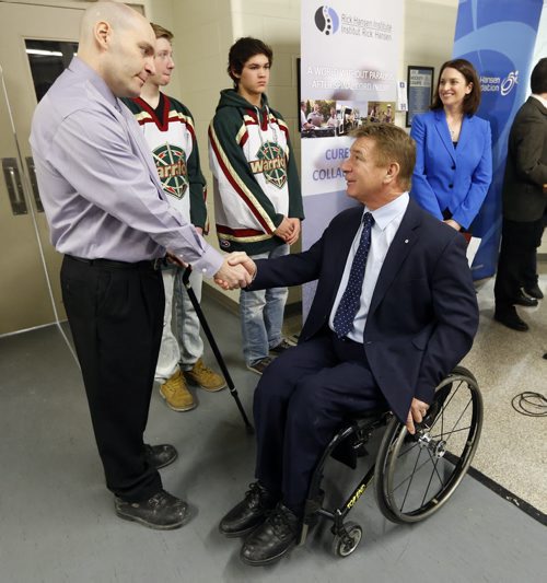 Rick Hansen shakes hands withScott Coates  who lives with a spinal cord injury he got 22 years ago , he has earned two masters degrees  and coached 5 AAA hockey Championship s  and was with members of his AAA Wpg Warriors   at the  newser with  Minister Erin Selby  The Mb. Gov. Is investing $3 million   over 5 years  with the Rick Hansen Foundation , Manitoba chapter of   The Canadian Paraplegic Ass.  To help people with spinal cord injuries recover  and return to their homes  and jobs . Story by Larry Kusch  Mar. 4 2014 / KEN GIGLIOTTI / WINNIPEG FREE PRESS