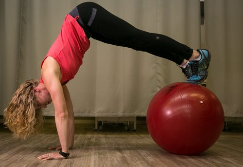 Stacey Dawson demonstrates the pike position of a pike and roll on an exercise ball, also known as a swiss ball.  For Tim Shantz 49.8 - core exercise 140303 - Monday, {month name} 03, 2014 - (Melissa Tait / Winnipeg Free Press)