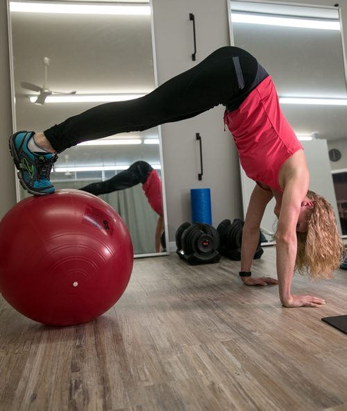 Stacey Dawson demonstrates the pike position of a pike and roll on an exercise ball, also known as a swiss ball.  For Tim Shantz 49.8 - core exercise 140303 - Monday, {month name} 03, 2014 - (Melissa Tait / Winnipeg Free Press)