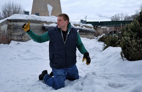 Re-enacting the assault, Sam Nemis, 31, a former 6 foot 3 300 pound Bison lineman, kneels in the snow by the River Trail at The Forks. He was stabbed while cross country skiing Sunday but managed to fight off three assailants who jumped him for the wallet he didn't have. 140305 - March 5, 2014 MIKE DEAL / WINNIPEG FREE PRESS