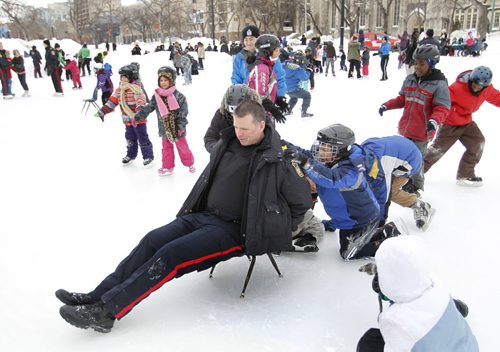 Winnipeg Police Patrol Sgt., Cadet Unit Scott McLennan gets a ride provided by children during the 5th annual Skates and Badges event Wednesday afternoon on the skating rink at Central Park. The purpose of the event is to bring the local schools, agencies, businesses, and the police together in the outdoor activity. Skates were available to students from the several schools that took part and hot refreshments and hot dogs served to the children. Wayne Glowacki / Winnipeg Free Press March 5   2014