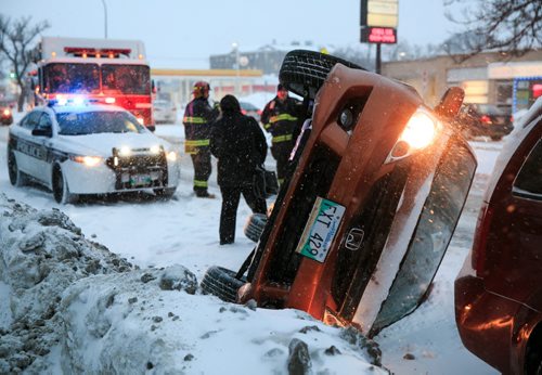 No one was injured in a car rollover on Henderson Highway near Greene Avenue. The vehicle collided with the snowbank and rolled, landing to rest barely a half metre behind Thomas Oliveira's parked van. Oliveira, who lives nearby, didn't hear the collision, but saw out his window a driver being helped out of the passenger window by a group of passersby.  140305 - Wednesday, {month name} 05, 2014 - (Melissa Tait / Winnipeg Free Press)
