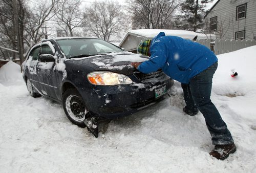 Winter Continues-George Engel pushes the family car which was stuck in a back alley off Grovenor Ave in River Heights Thursday morning- The Winnipeg area has seen near 8 CM of snow and could see another 7cm in the next 24 hours- Standup photo- Feb 07, 2014   (JOE BRYKSA / WINNIPEG FREE PRESS)