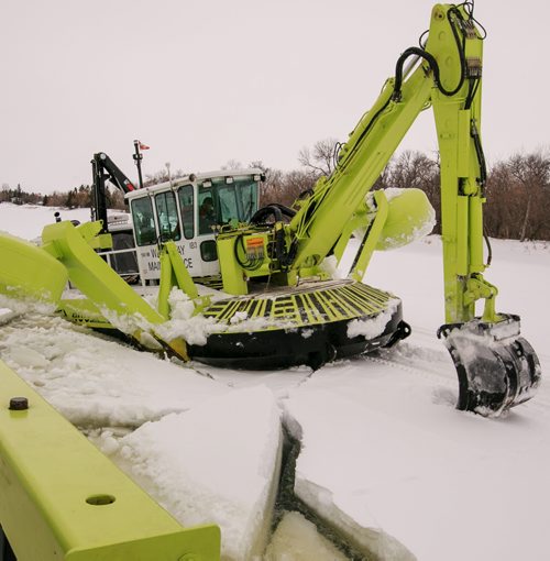 An Amphibex icebreaker uses the excavator arm to pull itself up out of the water and on to the ice, using the weight of the machine to break through the ice. Three Amphibex icebreakers are in use this season, through the end of March, to break up 30 km of ice on the Red River between Netley Lake and Selkirk. The breaking of the ice reduced the chances of ice jams along the river, which reduces the chances of flooding. Doug Speirs column 140305 - Wednesday, {month name} 05, 2014 - (Melissa Tait / Winnipeg Free Press)