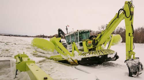 An Amphibex icebreaker uses the excavator arm to pull itself up out of the water and on to the ice, using the weight of the machine to break through the ice. Three Amphibex icebreakers are in use this season, through the end of March, to break up 30 km of ice on the Red River between Netley Lake and Selkirk. The breaking of the ice reduced the chances of ice jams along the river, which reduces the chances of flooding. Doug Speirs column 140305 - Wednesday, {month name} 05, 2014 - (Melissa Tait / Winnipeg Free Press)