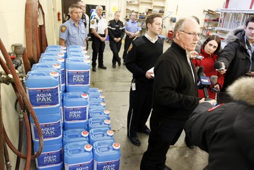 Update on City services relating to frozen water pipes. Winnipeg Fire Paramedic Service preparing water jugs for delivery at Winnipeg Fire and Paramedic Station 22, 1567 Waverley Street. Right, Randy Hull, Emergency Preparedness Coordinator answers questions at the presser. BORIS MINKEVICH / WINNIPEG FREE PRESS  March 7, 2014