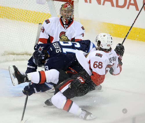 Winnipeg Jets' Jim Slater (19) and Ottawa Senators' Mike Hoffman (68) go down in a pile in front of goaltender Craig Anderson (41) during first period NHL hockey action at MTS Centre in Winnipeg, Saturday, March 8, 2014. (TREVOR HAGAN/WINNIPEG FREE PRESS)