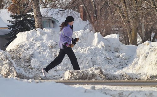A great day to get out and stretch the legs, just watch out for the 6' snowbanks and the melting muck on the streets. A jogger makes her way along the uneven ground along Wellington Crescent Sunday morning.  140309 March 9, 2014 Mike Deal / Winnipeg Free Press
