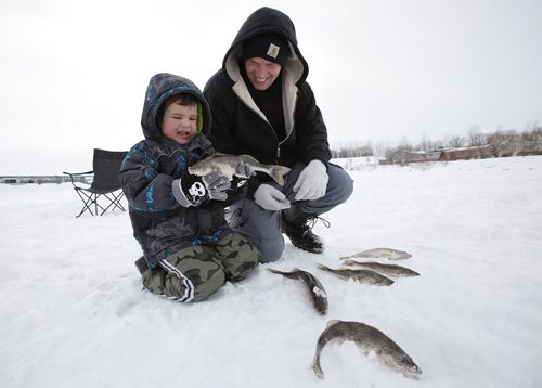 March 9, 2014 - 140309  - Four year old Colten Tousiquant checks his catch after a day of ice fishing with his dad, Justin, and his grandfather on the Red River just north of Lockport Sunday, March 9, 2014. Ice fishers must remove their huts by the end of today. John Woods / Winnipeg Free Press