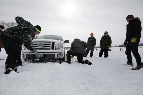 March 9, 2014 - 140309  - Friends help dig out Darryl Giesbrecht after he tried to help another stuck truck after their day of ice fishing on the Red River just north of Lockport Sunday, March 9, 2014. Ice fishers must remove their huts by the end of today. John Woods / Winnipeg Free Press